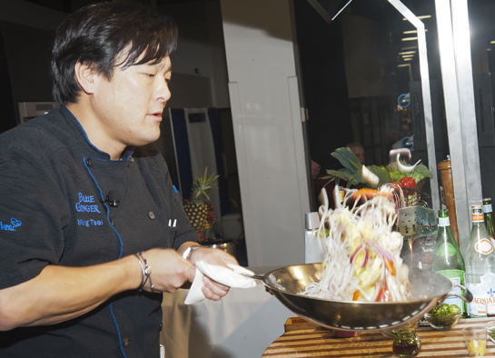 Chef Ming Tsai flipping food high in wok
