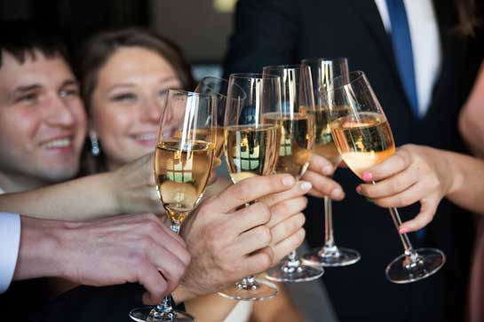 Six glasses of wine raised in toast at a party