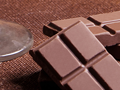 stem of glass beside piece of chocolate bar 