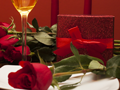 Detail of champagne glass, box of chocolate and a red rose