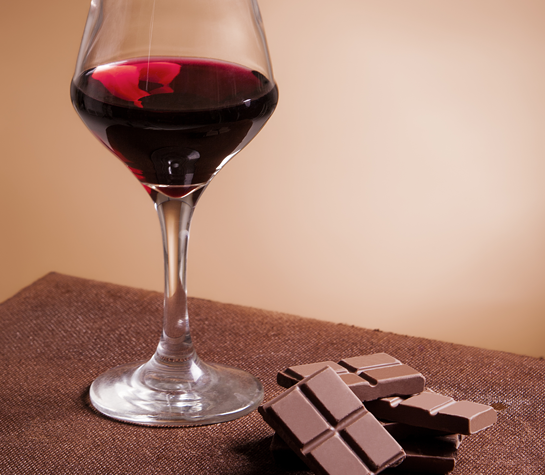 glass of Port and short stack of chocolate
